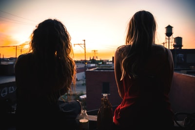 The two women sitting on the roof to watch the sunset
